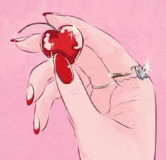 a woman's hand holding a heart shaped ring