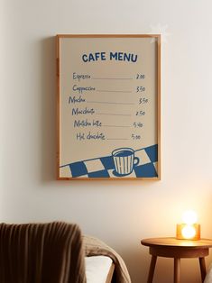 a coffee menu hangs on the wall next to a table with a chair and lamp