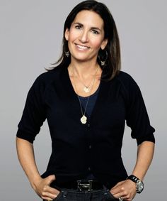 a woman standing with her hands on her hips and smiling at the camera while wearing a black cardigan