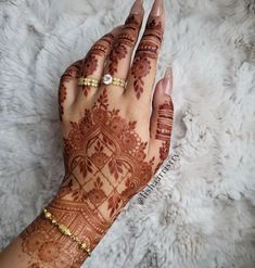 a woman's hand with henna tattoos on it