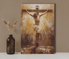 a painting of jesus on the cross next to a vase