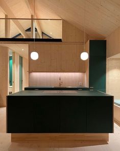 a kitchen with an island in the middle and two lights hanging from it's ceiling