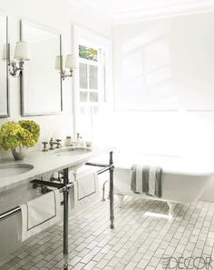 a white bathroom with two sinks and a bathtub