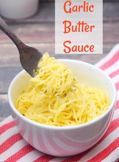 garlic butter sauce in a white bowl on a red and white striped towel with a spoon