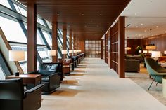 an empty lobby with couches and lamps on the wall next to large glass windows