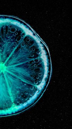 an orange slice with water droplets on it's surface, in the middle of black background