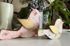 two wooden birds sitting on top of a table next to a vase with flowers in it