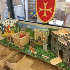 some toys are sitting on the shelf in front of a window with a shield above it