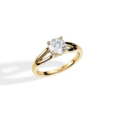 a yellow gold engagement ring with a single diamond in the center, on a white background