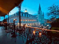 an outdoor restaurant with tables and chairs on the balcony at night, lit up by candles