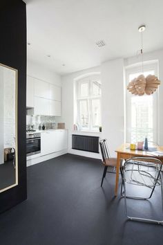 an empty kitchen with black floors and white walls