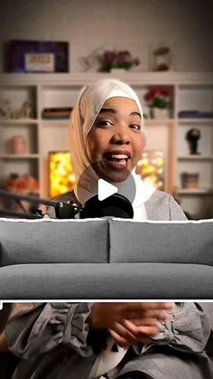 a woman with a headscarf on sitting in front of a couch