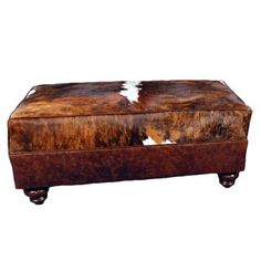 a brown and white cowhide covered ottoman