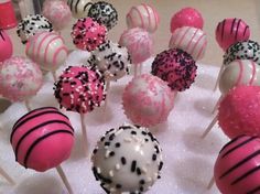 cake pops with sprinkles and pink and white frosting are on a table