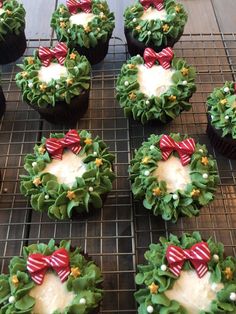 cupcakes decorated like wreaths with bows and pearls are on a cooling rack