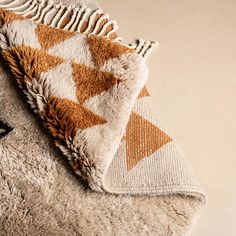 a brown and white blanket laying on top of a chair