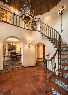 a spiral staircase in a home with tile flooring and red tiles on the ground