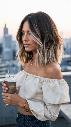 A delightful mix of brunette and blonde balayage, this medium-length hair is perfect for a casual day out. The soft waves and blonde accents create a dynamic and refreshing look. I imagine this on someone with an oval face, as the volume and texture add a lively touch. The client is casually dressed in a flowy off-shoulder top, holding a coffee cup, enjoying a sunny day on a city rooftop. This look is fantastic for those wanting a laid-back yet chic style, perfect for brunch or a stroll in the city. Medium Length Brown And Blonde Hair, Short Hair Color Ideas Balayage, Balayage For Shoulder Length Hair, Hair Colour Ideas Shoulder Length, Womens Haircuts Medium Shoulder Length Trending Hairstyles, Lob Color Ideas, Hair Inspiration Oval Face, How To Soft Waves Short Hair, Shoulder Length Hair Fall 2024