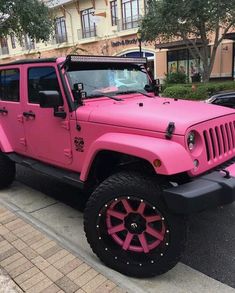 a pink jeep is parked on the side of the road