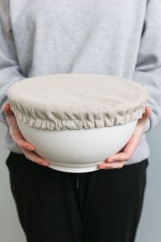 a person holding a white bowl in their hands