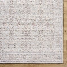 a white rug with an intricate design on the top and bottom, sitting on a wooden floor