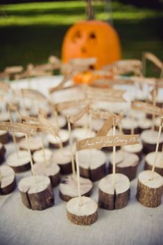 cupcakes are arranged on wooden slices for a halloween themed dessert table with a pumpkin in the background