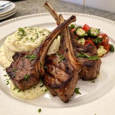 a white plate topped with steak and mashed potatoes