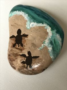 a painted rock with two children playing on the beach