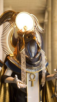 an egyptian statue is dressed in gold and black with a large headpiece on it's face