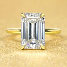 an emerald - cut diamond sits on a gold surface