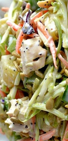 a salad with chicken, carrots and lettuce in it on a white plate