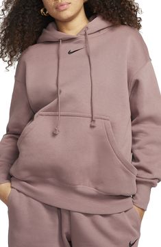 Exaggerated features like an oversized kangaroo pocket and wide ribbing enhance the roomy fit of this sporty hoodie with a cozy brushed fleece interior. 27 1/2" length (size medium) Drawstring hood Kangaroo pocket 80% cotton, 20% polyester Machine wash, tumble dry Imported Nike Sportswear Phoenix Fleece, Sporty Hoodie, Nike Sportswear Women, Loungewear Luxury, Cycling Fashion, Oversized Pullover, Denim Leggings, Shorts With Tights, Sportswear Women