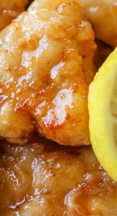 closeup of chicken with sauce and lemon wedges