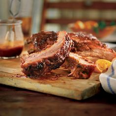 ribs on a cutting board with sauce and orange slices