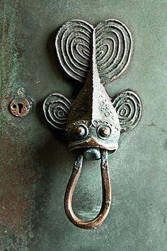 an old door handle with a face on it