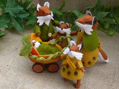 three stuffed animals are riding in a toy wagon with carrots and peas on it