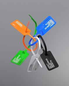 an assortment of luggage tags hanging from a metal hook on a gray background with clippings attached to them