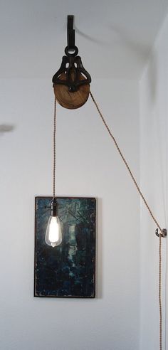 a light that is on the side of a wall next to a painting and lamp