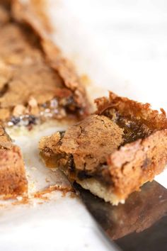 a close up of a piece of cake on a table with a knife in it