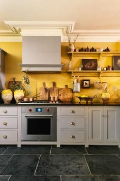 a kitchen with yellow walls and gray cabinets