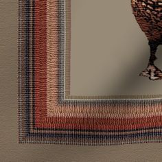 a brown and black bird sitting on top of a rug in front of a mirror