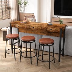 three stools are sitting at the bar in front of a couch with a coffee table on it