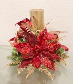 a red and gold poinsettia arrangement on a glass table