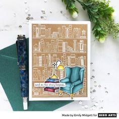 a card with an image of a blue chair and books on it, next to a pen