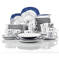 a table topped with lots of white and blue dishes next to each other on top of a reflective surface