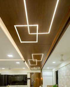 a kitchen with white counter tops and wooden ceiling lights above the stove top ovens