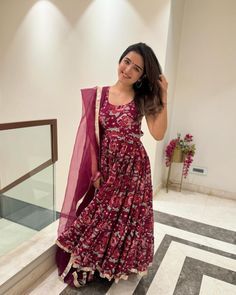 a woman in a red dress is posing for the camera with her hand on her head