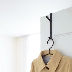 a coat hanger is hanging on the wall next to a shirt collared jacket