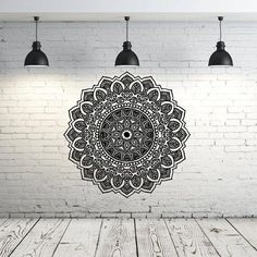 an image of a black and white wall hanging on a brick wall with three lights