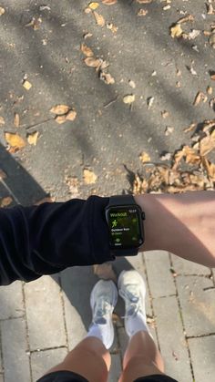 two people standing next to each other with their feet on the ground and one person wearing an apple watch